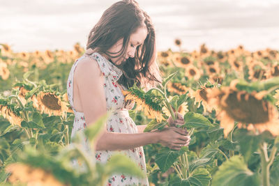 Close-up of woman with pink flowers on field