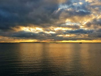 Scenic view of sea against dramatic sky during sunset