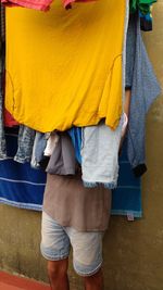 Low section of man hiding behind clothesline 