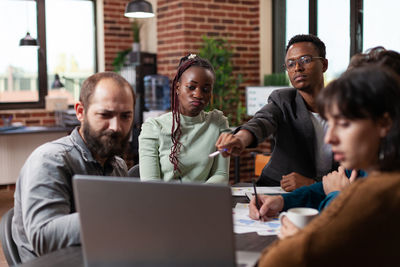 Manager pointing at laptop at business meeting in office