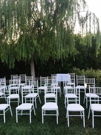 Empty chairs and table on field