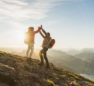 Austria, salzkammergut, cheering couple reaching mountain summit