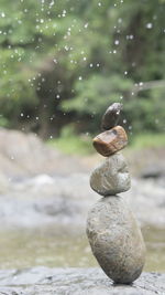 Close-up of stone stack on rock in lake