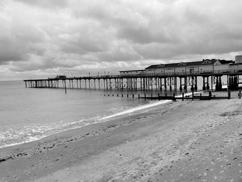 Pier on beach against sky