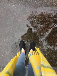 Low section of woman standing on wet street