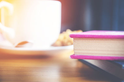 Close-up of books and coffee cup on table