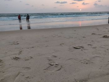 People on beach against sky