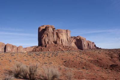 Rock formations on landscape against blue sky