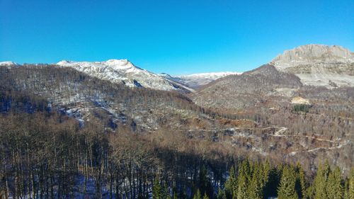 Scenic view of snowcapped mountains against clear blue sky