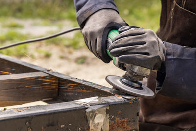 Close-up of person working on metal