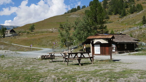 Built structure on field by trees against sky