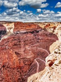 Rock formations on landscape against cloudy sky