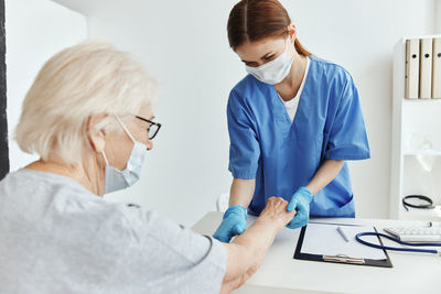 Rear view of woman using smart phone on table