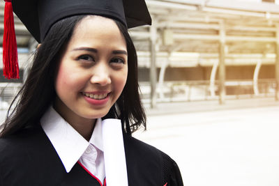 Portrait of smiling young woman wearing mortar board