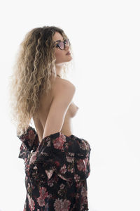 Rear view of young woman standing against white background