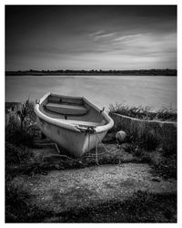 Boat moored at shore against sky