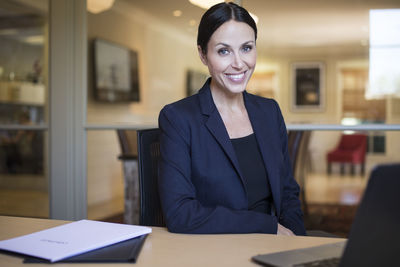 Smiling businesswoman in office with computer