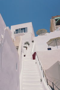 Staircase by building against clear blue sky