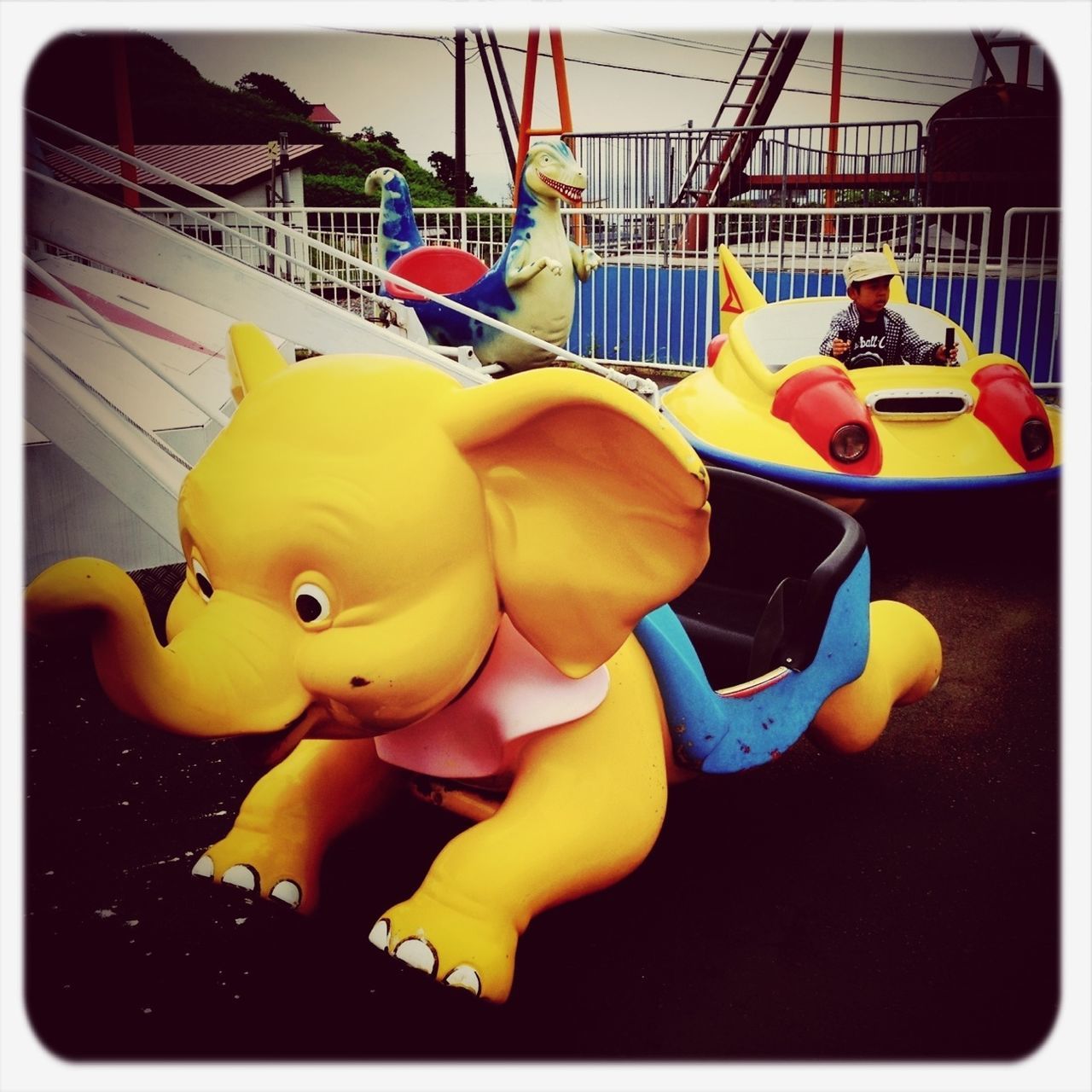 transfer print, yellow, auto post production filter, toy, childhood, animal representation, day, multi colored, outdoors, art and craft, sunlight, close-up, no people, art, creativity, playful, chair, hanging, playing, low angle view