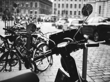 Bicycle parked on street against building in city