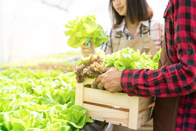 Woman holding food while standing by plants