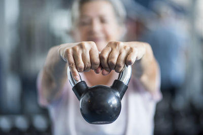 Close-up of woman holding kettle bell