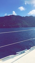 Scenic view of sea by mountains against sky