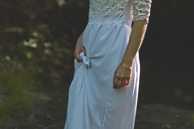 Midsection of woman in white dress