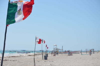 Mexican flags and tourists on beach