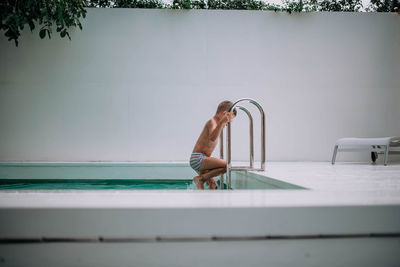 Side view of shirtless man in swimming pool