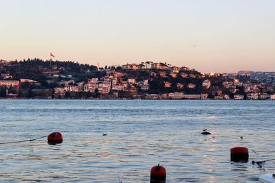 View of buildings in sea at sunset