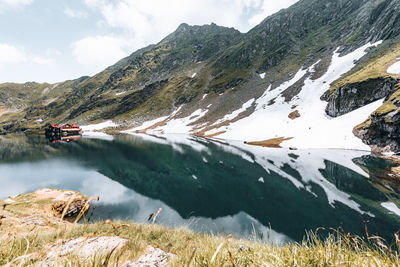 Snow patches on mountain ridge  with lake and reflection