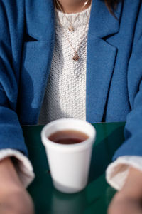 Midsection of man holding coffee cup