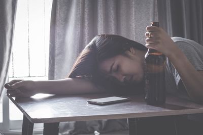 Depression woman holding a bottle of beer.