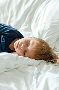 Cute boy sleeping on bed at home