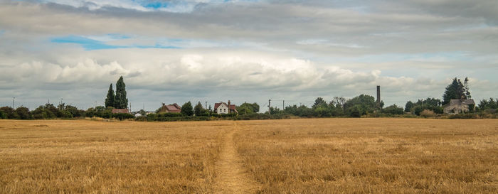 Rural landscape against cloudy sky