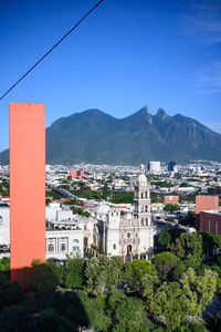 High angle view of buildings in city against clear blue sky