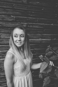 Smiling young woman standing against wall