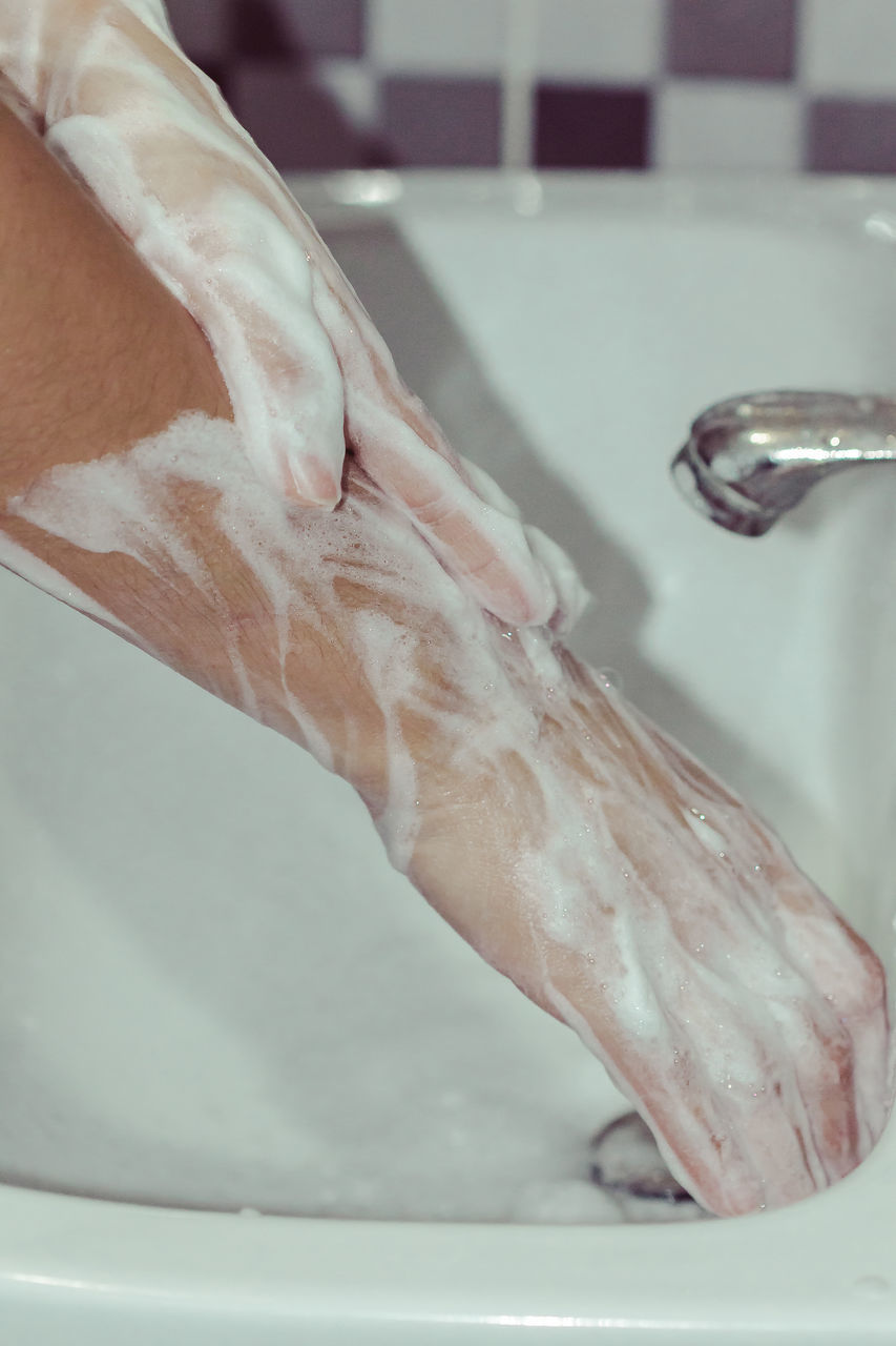 LOW SECTION OF PERSON LEGS IN BATHTUB