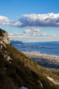 Scenic view of sea and mountains against sky