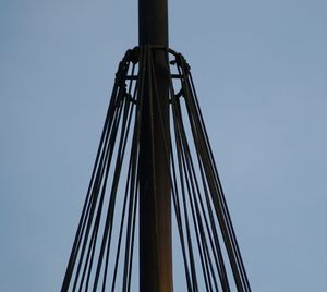 Low angle view of electricity pylon against clear sky