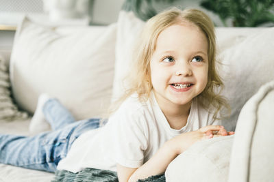 Little girl with blond hair having fun at home.