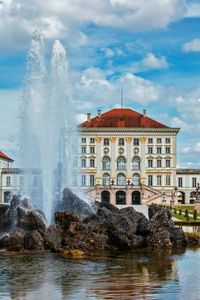 Fountain in city against sky