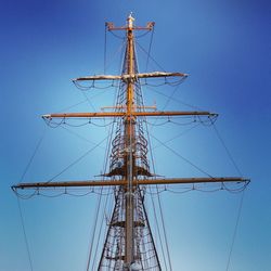 Low angle view of electricity pylon against blue sky