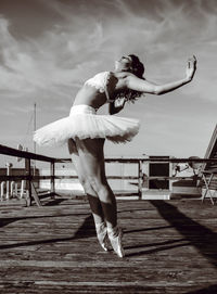 Full length of young woman standing on pier