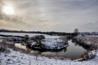 Scenic view of snow covered field against sky