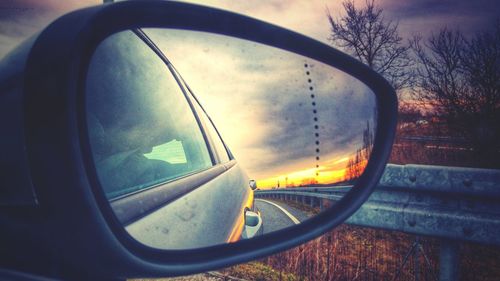 Reflection of clouds in side-view mirror