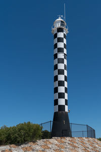 Low angle view of lighthouse against clear blue sky