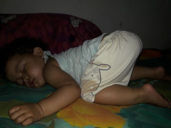 Boy sleeping on bed at home