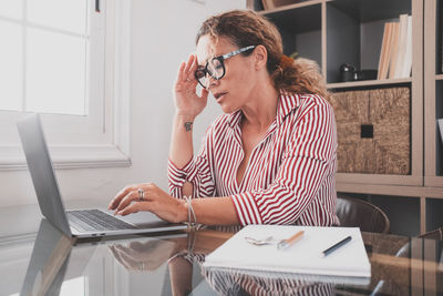 Woman using mobile phone at home